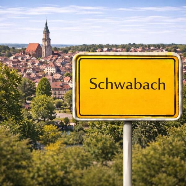 Gelbes Ortsschild Schwabach mit Stadt im Hintergrund